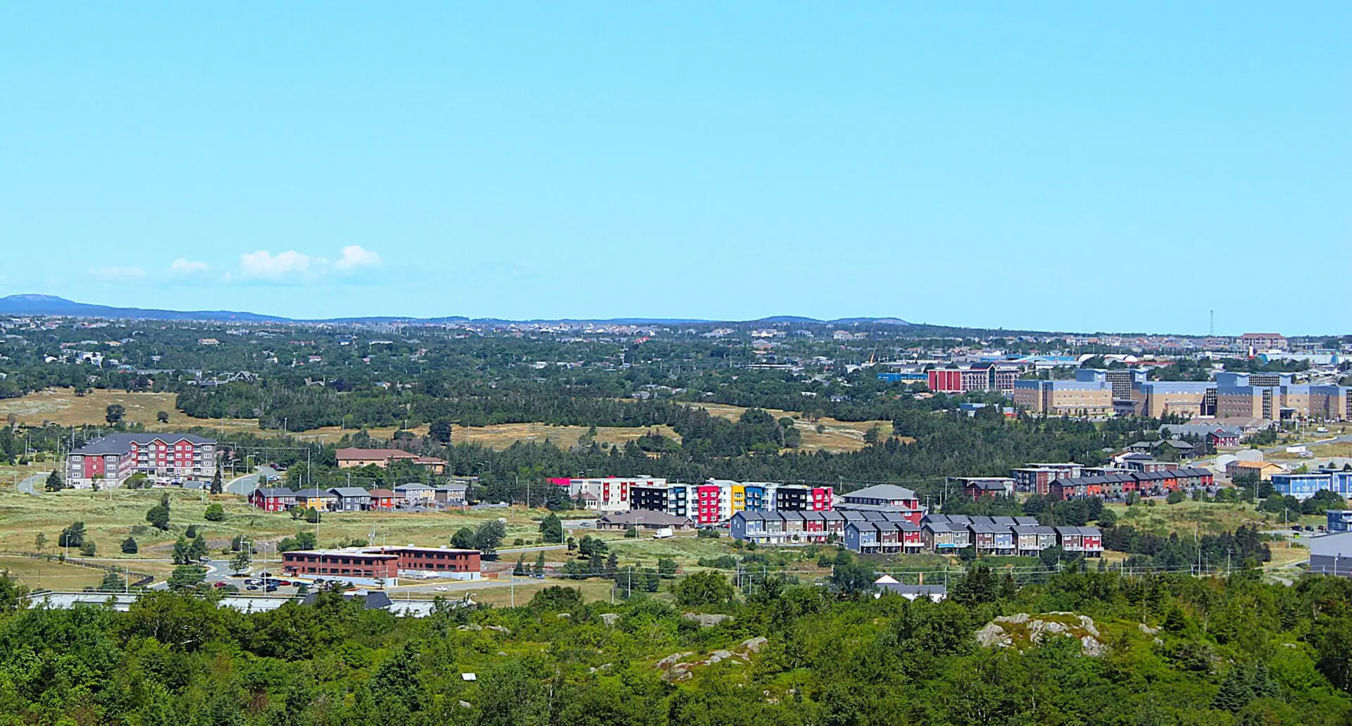 Panoramic view of a city with colorful buildings under a clear blue sky.