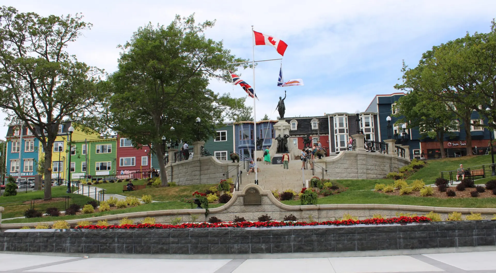 A Canadian war memorial with flags in a town square.