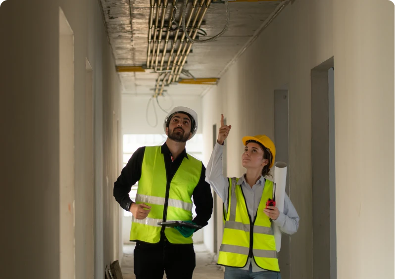 Construction workers inspecting ceiling wires