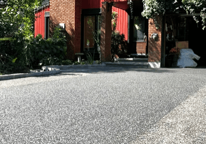 A residential street with trees and houses on a sunny day.